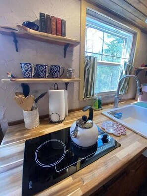 Enjoy cooking in the fully equipped kitchen with induction cooktop, sink, and ample storage.