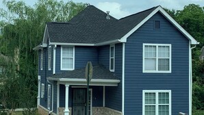 A two-story house with a dark blue exterior, a front porch, and a garage. - Spacious 4-bedroom house  walking distance to Mercedes Benz Stadium & Downtown (Atlanta)