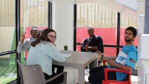 A modern indoor space with large windows, a table, and chairs. - TaTe Village - Hostel (Windhoek)