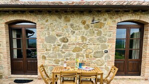 A stone building with two wooden doors and a tiled roof. - Villa with private pool and panoramic view in beautiful Val d'Orcia (San Giovanni d'Asso)