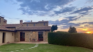A stone house with a patio, a swimming pool, and a hedge. - Villa with private pool and panoramic view in beautiful Val d'Orcia (San Giovanni d'Asso)