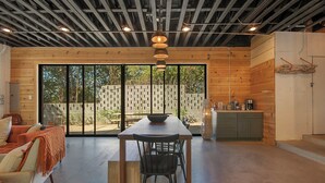 Ein modernes Interieur mit einem Holzespeisetisch, schwarzen Stühlen und einer Küchenzeile mit Schränken und einer Arbeitsplatte.