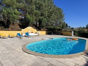 Ein Pool mit Liegestühlen und einer Terrassenanlage.