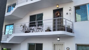 Ein mehrstöckiges Gebäude mit Balkonen, großen Fenstern und einer Tür mit einem Kranz.