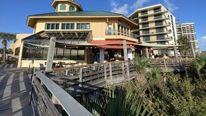 Un restaurante frente al mar con terraza exterior, un porche cubierto y vistas al océano.