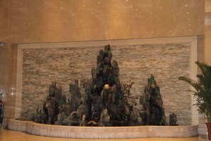 A large indoor rock garden with a circular stone border. - Xingyu Tangsuge Desert Hot Spring Hotel (Otog Front Banner)