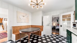 A modern kitchen with a round table, white cabinetry, and a black and white hexagonal tile floor. - Tims Ford Lake, Sewanee, and Historic Downtown Winchester (Winchester)
