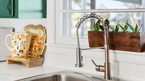 A kitchen with two stainless steel sinks, a window with a view, and a wooden planter with green plants. - Tims Ford Lake, Sewanee, and Historic Downtown Winchester (Winchester)