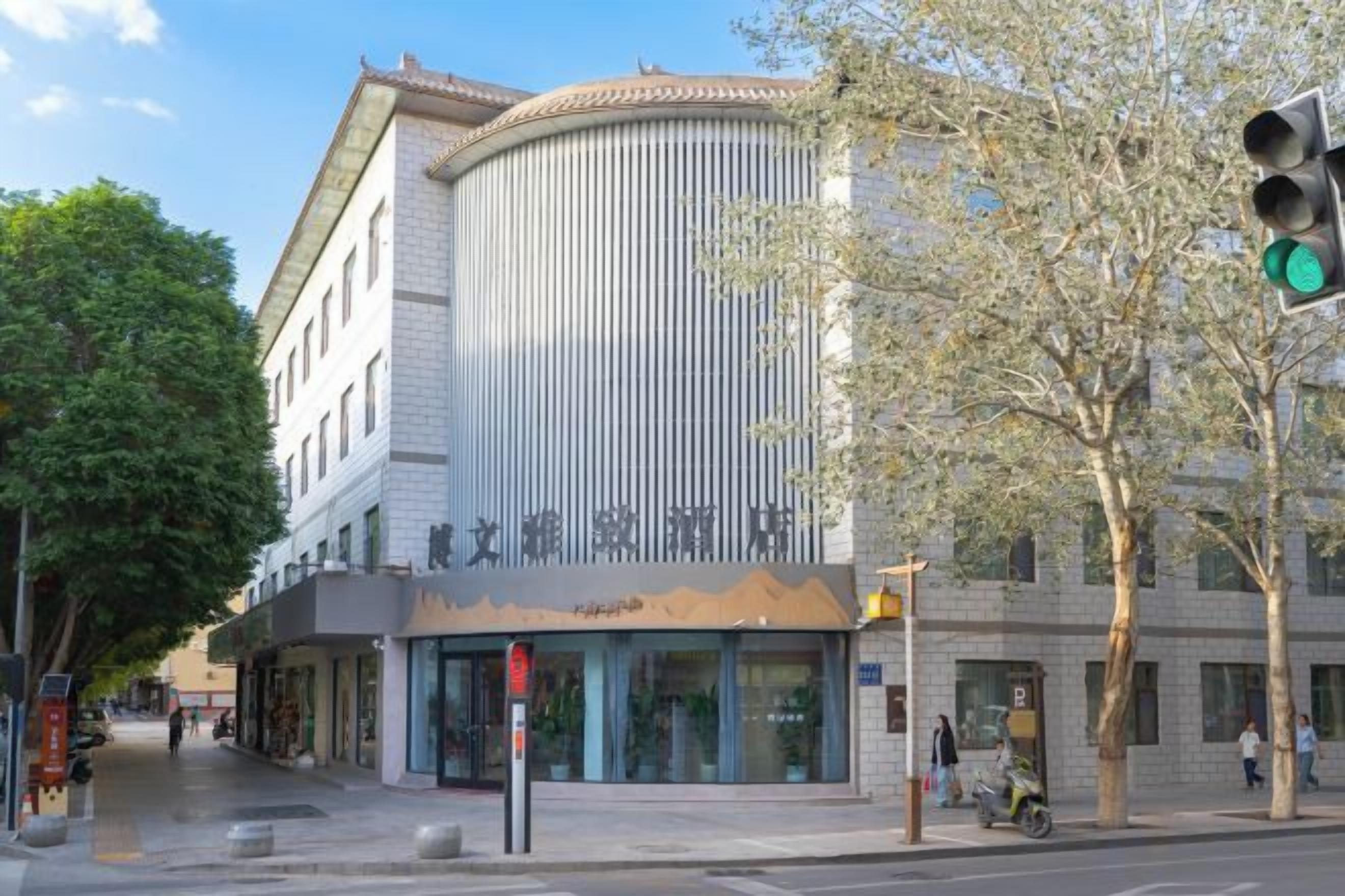 A building with a curved facade, large windows, and a sign with Chinese characters.