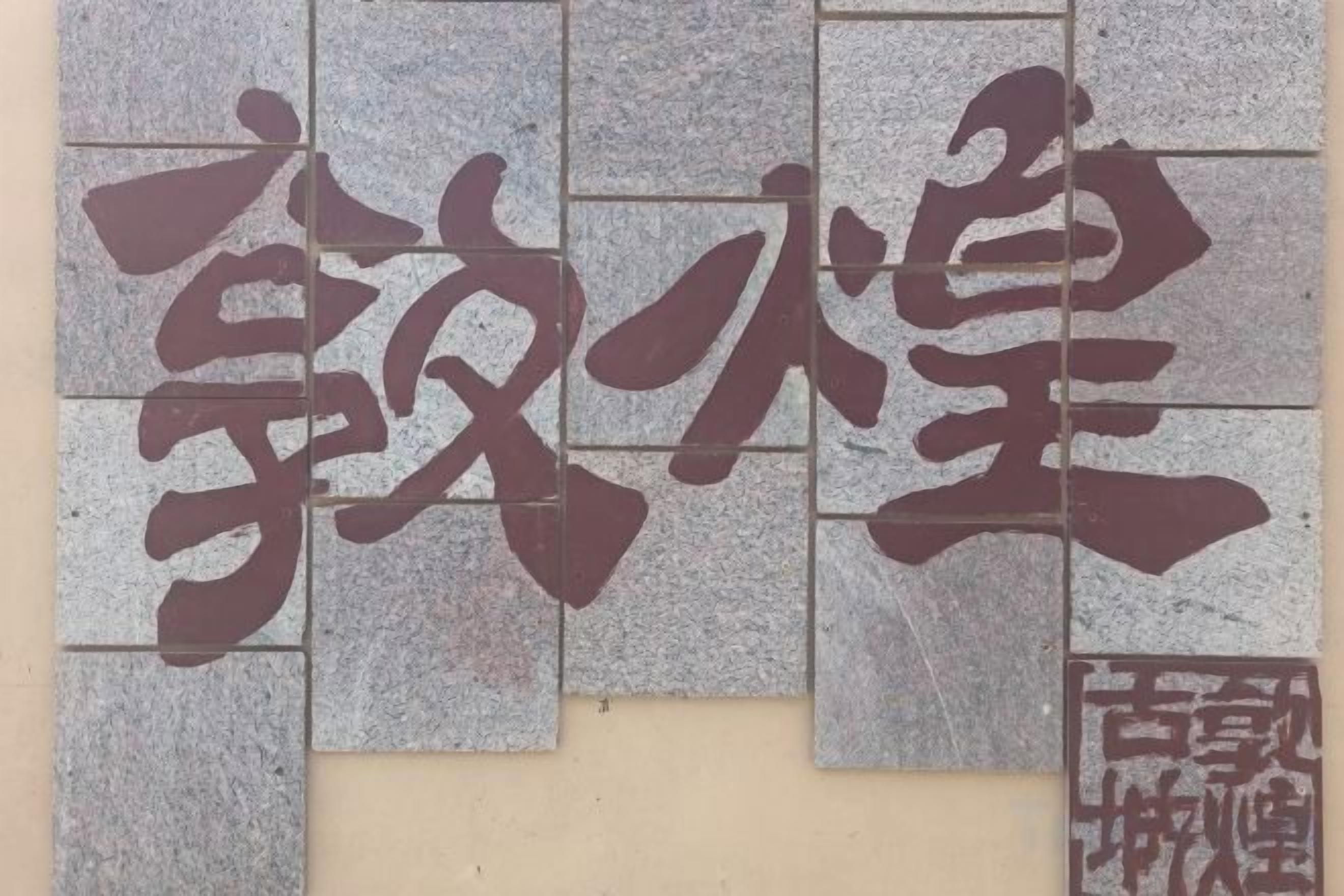 A wall with large, dark Chinese characters.