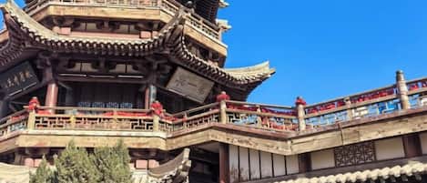 Un bâtiment traditionnel de style pagode, à plusieurs niveaux, doté de balcons et de rampes.