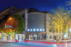 A hotel with a modern facade, a prominent entrance, and a well-lit street in the foreground. - Bowen Elegant Hotel (Dunhuang Night Market Shop) (Dunhuang)