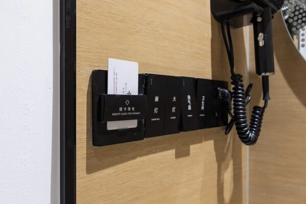 Une porte de chambre d’hôtel avec un téléphone noir et un lecteur de carte.