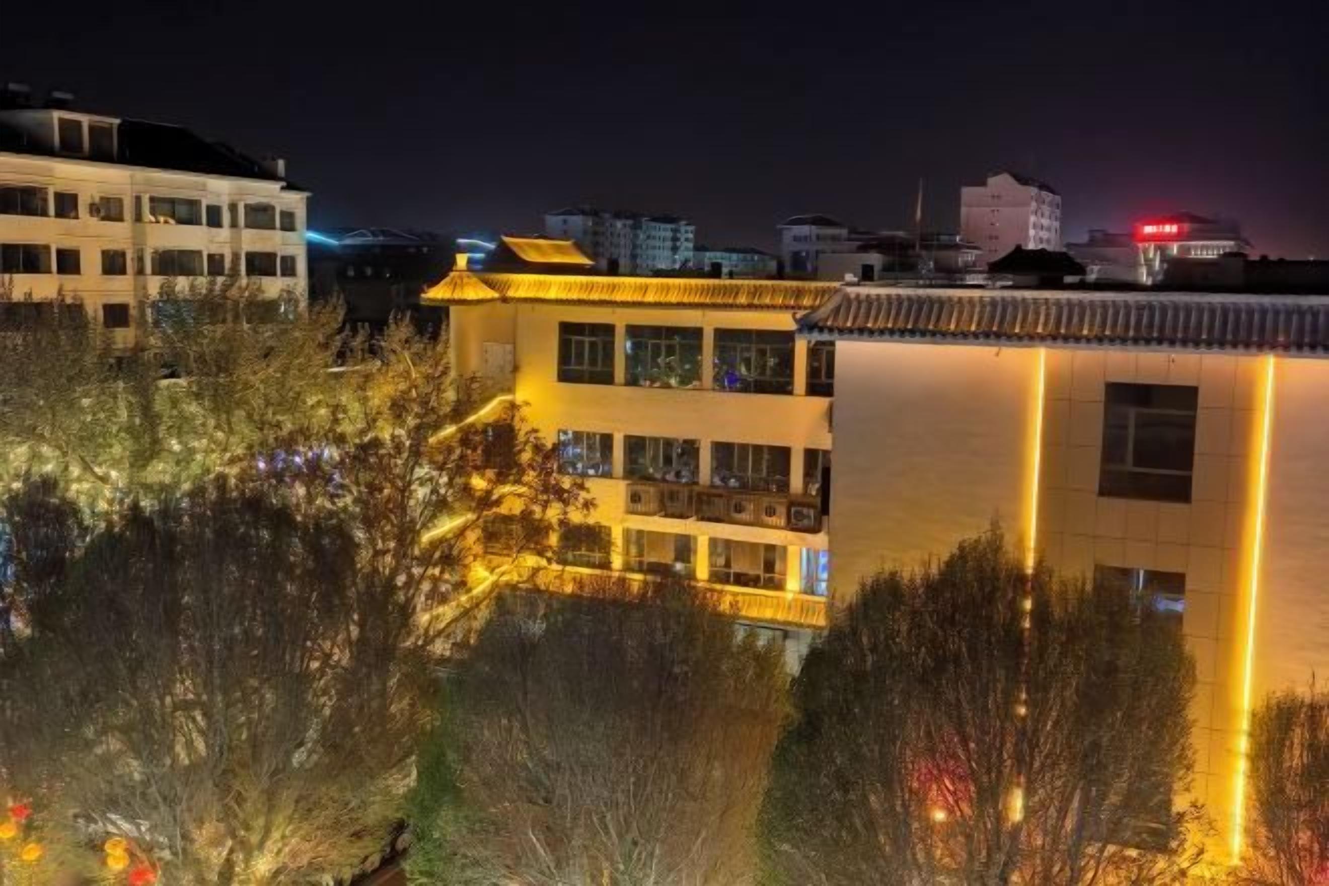 Een gebouw met meerdere verdiepingen, balkons en een spiegelend wateroppervlak ervoor.