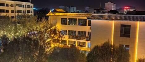 Een gebouw met meerdere verdiepingen, balkons en een spiegelend wateroppervlak ervoor.