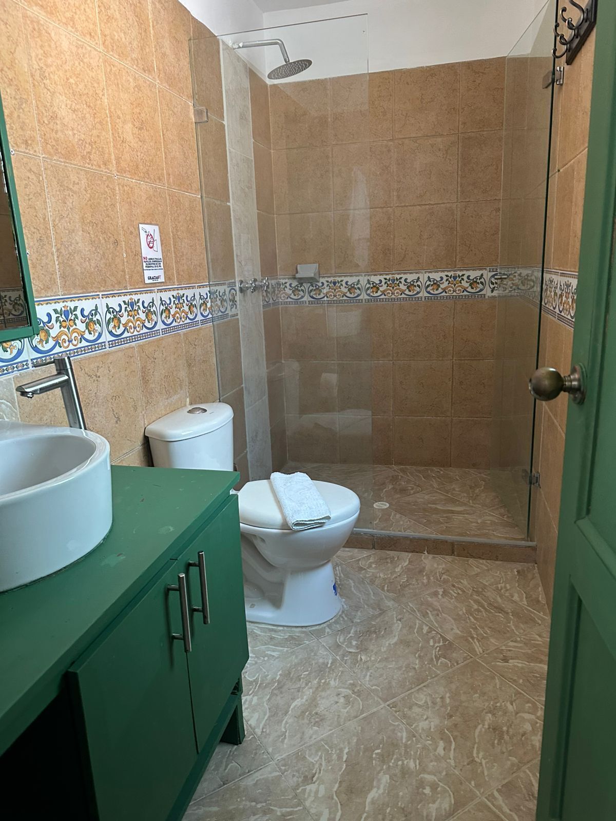 A bathroom with a shower, toilet, and sink.