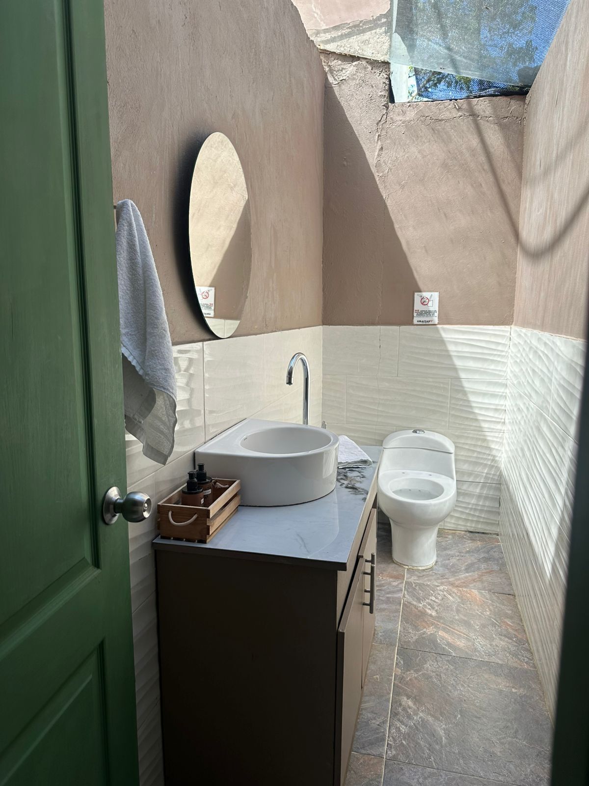 Een kleine badkamer met een wastafel, toilet en spiegel.