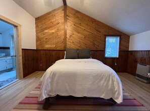 View looking into the primary bedroom with a queen bed and en-suite full bath 