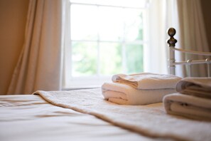 A neatly made bed with a folded white towel and a blanket. - Manor House Moreton - Entire Holiday Home (Dorchester)