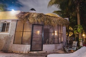 A small, single-story building with a thatched roof, large windows, and a door. - Private Beachhouse Hacienda Antigua (El Cuyo)