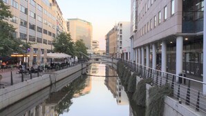 A canal with buildings on either side, a pedestrian bridge, and outdoor seating areas. - Charming House Close to Everything (Aarhus)