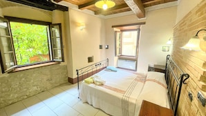 A bedroom with a bed, a window, a radiator, and a lamp. - Apt 4 - Forget all Your Troubles - Relax in Paradise ! Air Con, Wifi! Sleeps 4 (Spoleto)