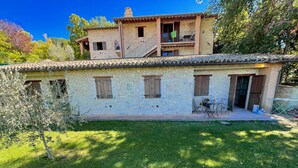 A stone house with a balcony, a small garden, and a table with chairs outside. - Apt 4 - Forget all Your Troubles - Relax in Paradise ! Air Con, Wifi! Sleeps 4 (Spoleto)