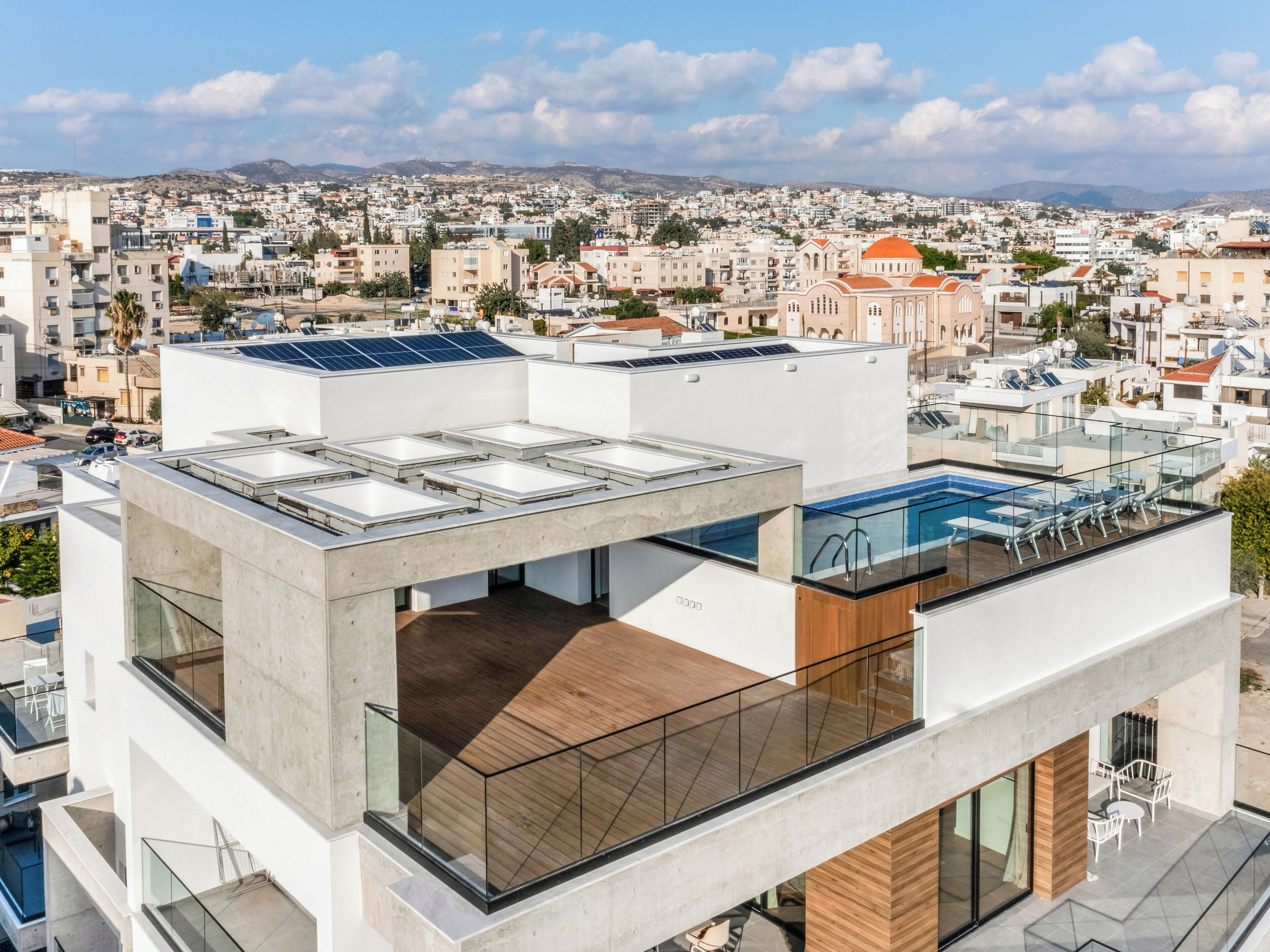 A modern building with a rooftop pool and solar panels.