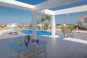A rooftop terrace with a pool, outdoor seating, and a view of the sea. - Protaras Holiday Villa Ds116 (Paralimni)