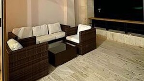 An outdoor seating area with a sofa and chairs, a fireplace, and a large window. - Srvittinivillas Aptla/ Best View/ Fam/couple/ Team/ Work Tr/ Casa de Campo Rv (La Romana)