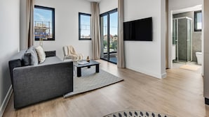 A modern living room with a grey sofa, a coffee table, and a TV mounted on the wall. - Sanders Crystal 2 - Dreamy 3-bdr. Apt. With Shared Rooftop (Limassol)