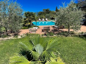 A pool area with lounge chairs and a clear view of a mountain in the background. - Apt 2 in Spoleto Stunning Grounds Panoramic Views all Around You! Sleeps 4 (Spoleto)