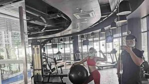 Ein Fitnessstudio mit Trainingsgeräten, großen Fenstern und modernem Design.