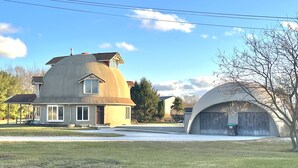 Una casa con una grande struttura a forma di cupola e un edificio più piccolo ad essa collegato.