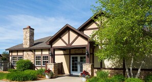 Guests may check in at this traditional building with a gabled roof and chimney, surrounded by well-maintained landscaping.