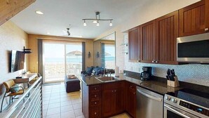 A modern kitchen with wooden cabinets, a stainless steel oven, and a large window overlooking a balcony. - Southern Jewel 1 Bedroom | 1.5 Baths | Sleeps 4 (Navarre Beach)