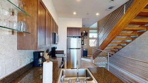 A kitchen with a stainless steel sink, wooden cabinets, and a built-in microwave. - Southern Jewel 1 Bedroom | 1.5 Baths | Sleeps 4 (Navarre Beach)
