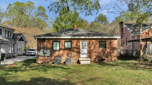 A single-story brick house with a front porch, a garage, and a small front yard. - Southend Home walk 2 *Uptown Panthers Stadium Restaurants (Charlotte)