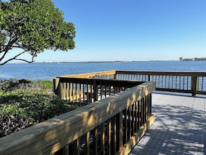 A wooden deck with a railing overlooking a body of water.