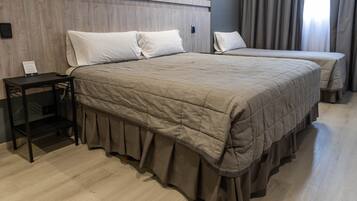 A hotel room with a large bed, a bedside table, and a small desk.