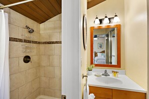 Un bagno con doccia, lavandino e specchio.