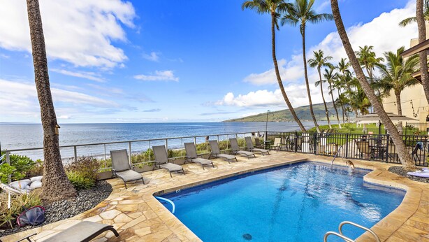 A pool with lounge chairs and a view of the ocean. - Sugar Beach beauty, Your 2bd Oceanfront Escape (Kihei)