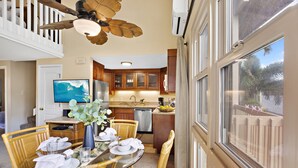 A dining area with a glass table, wicker chairs, and a ceiling fan. - Sugar Beach beauty, Your 2bd Oceanfront Escape (Kihei)