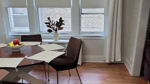 A dining area with a wooden table, chairs, a fruit bowl, and a potted plant. - Oak Park, IL, entire house, short walk to train. (Oak Park)