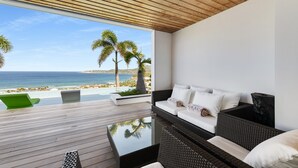 A modern room with a wooden ceiling, a glass wall, and a view of the beach and ocean. - Villa Grace | Ocean View - Located in  Fabulous Anse des Cayes with Private Pool (Anse des Cayes)