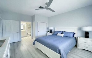 A bedroom with a bed, nightstands, a ceiling fan, and a door leading to another room. - Naples Condo-Instant Book!  Modern Living + Golf Courses Near Fifth Ave & Marco (Naples)
