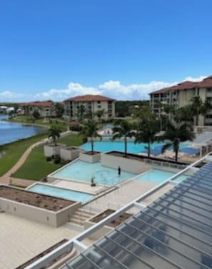 Ein Hotel mit Poolbereich, mehreren Gebäuden und Blick auf das Wasser.