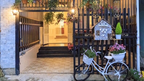 A house with a gated entrance, a bicycle, and potted plants. - Chivo House - The House Of Peace (Thành phố Đà Lạt)