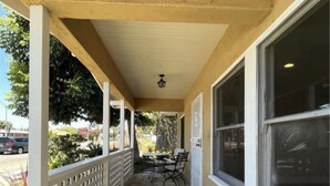 A covered porch with a 'Welcome' mat, a table with chairs, and a view of the street. - 1.3 miles from Disneyland (Anaheim)