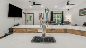 Une cuisine moderne dotée d’un îlot central, d’appareils électroménagers intégrés et d’un ventilateur de plafond.